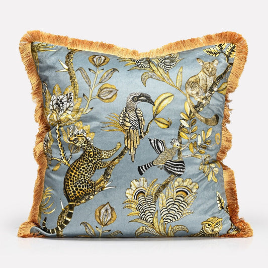 A 60x60cm cushion cover with a rich blue-grey velvet background, detailed with golden botanical and animal illustrations, and framed with plush gold fringe.