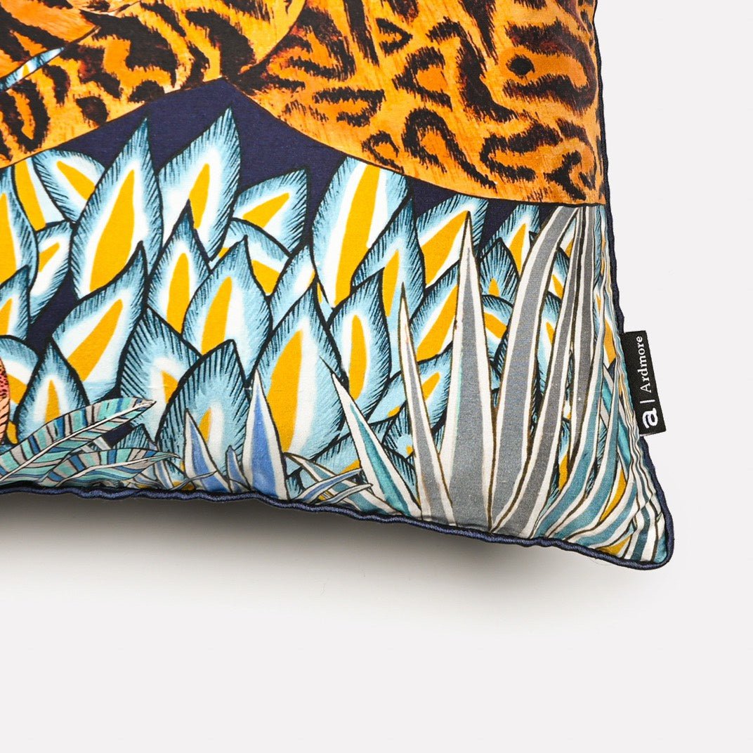 Close-up of the Cheetah Kings Forest Tanzanite silk cushion cover, highlighting the detailed geometric and tropical patterns in blue and gold tones.