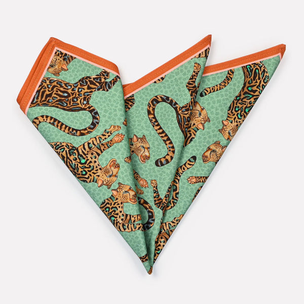 A set of Ardmore Cheetah King napkins in Jade, neatly folded to highlight the elegant cheetah motif and the refined blend of jade, turquoise, and gold hues.