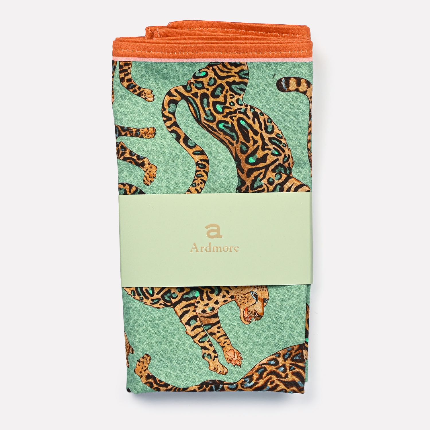 A close-up of the Ardmore Cheetah King napkin in Jade, showcasing the fine detail of the cheetah pattern and the smooth, high-quality cotton fabric.