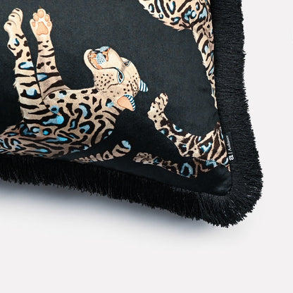Close-up of the Cheetah Kings Starry Nights velvet cushion cover, showcasing the detailed cheetah patterns and the elegant black fringe edging.