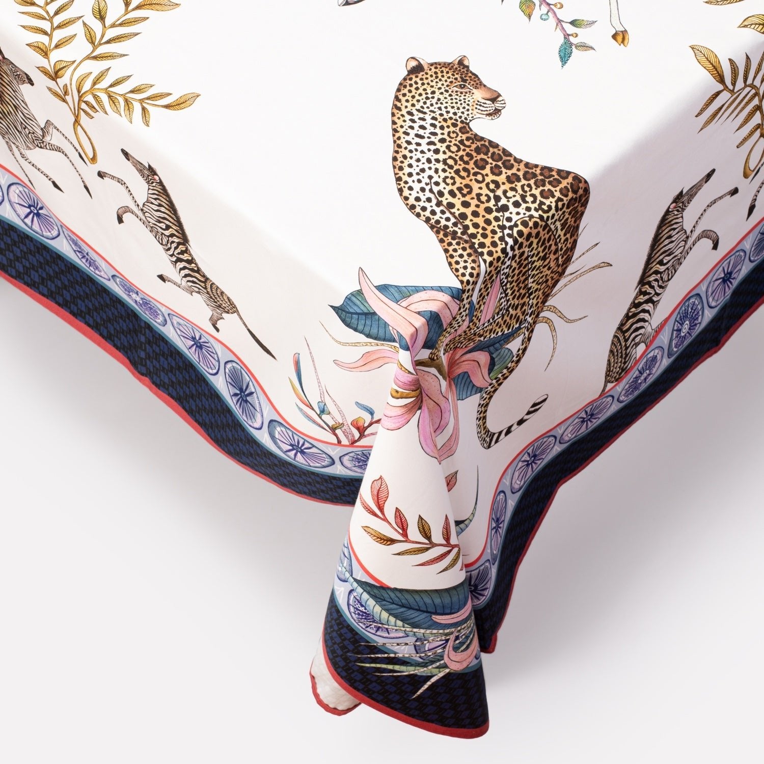 A macro shot highlighting the tablecloth’s bordered edge, displaying a leopard motif surrounded by stylised floral accents.