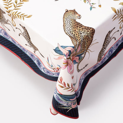 A macro shot highlighting the tablecloth’s bordered edge, displaying a leopard motif surrounded by stylised floral accents.