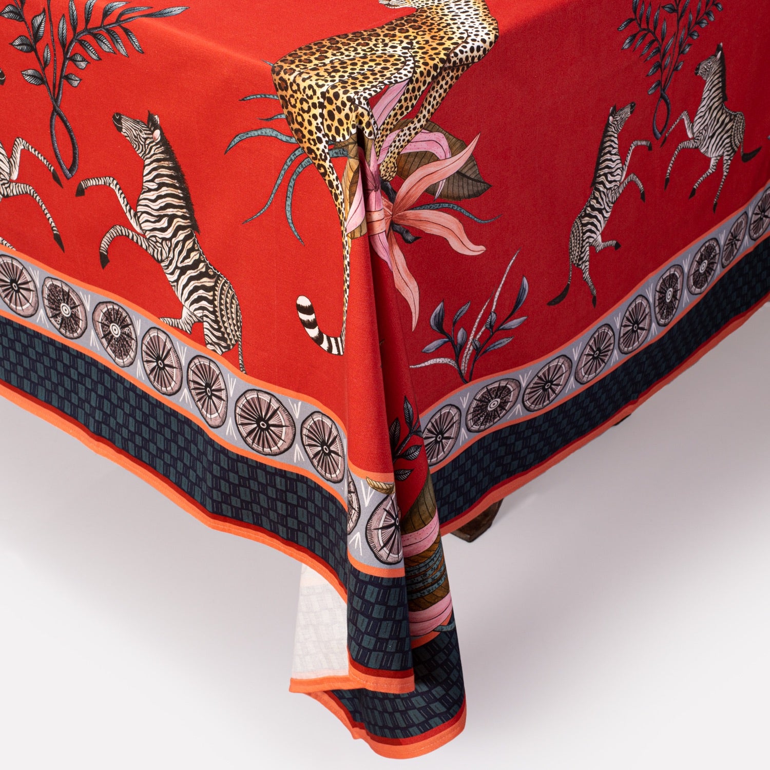 A close-up view of a poised leopard amidst stylised floral accents, showcasing the rich texture and vibrant colours of the fabric.