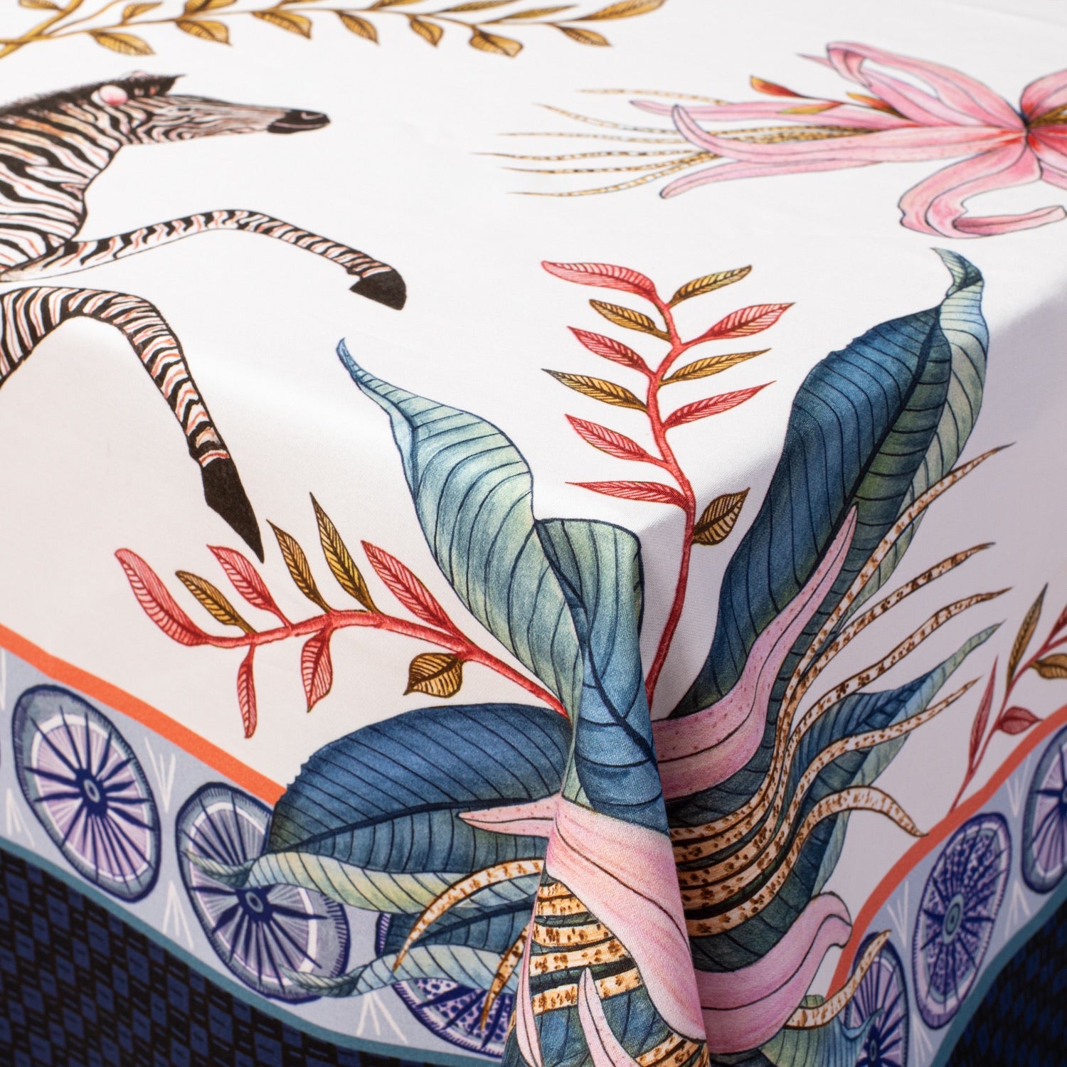 A detailed close-up highlighting the fine illustration of a zebra's face, surrounded by intricate florals along the fabric border.