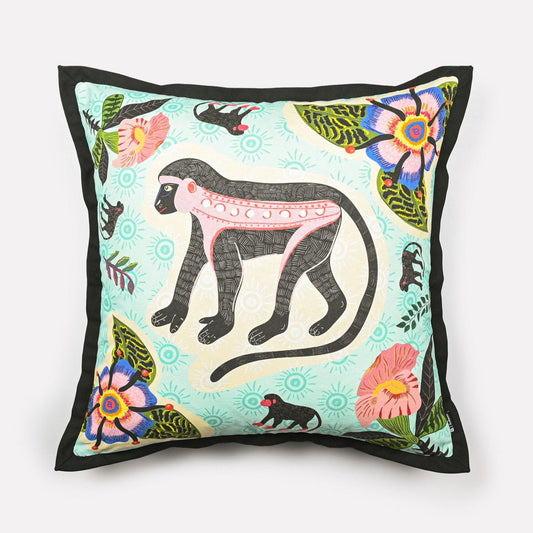 Front view of the Meandering Monkey Oasis cushion cover featuring a playful monkey design surrounded by vibrant floral patterns on a light background.
