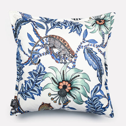 Front view of the Monkey Bean Tanzanite cushion cover, showcasing a harmonious design of tropical foliage and wildlife in vibrant blue and green tones on a white base.