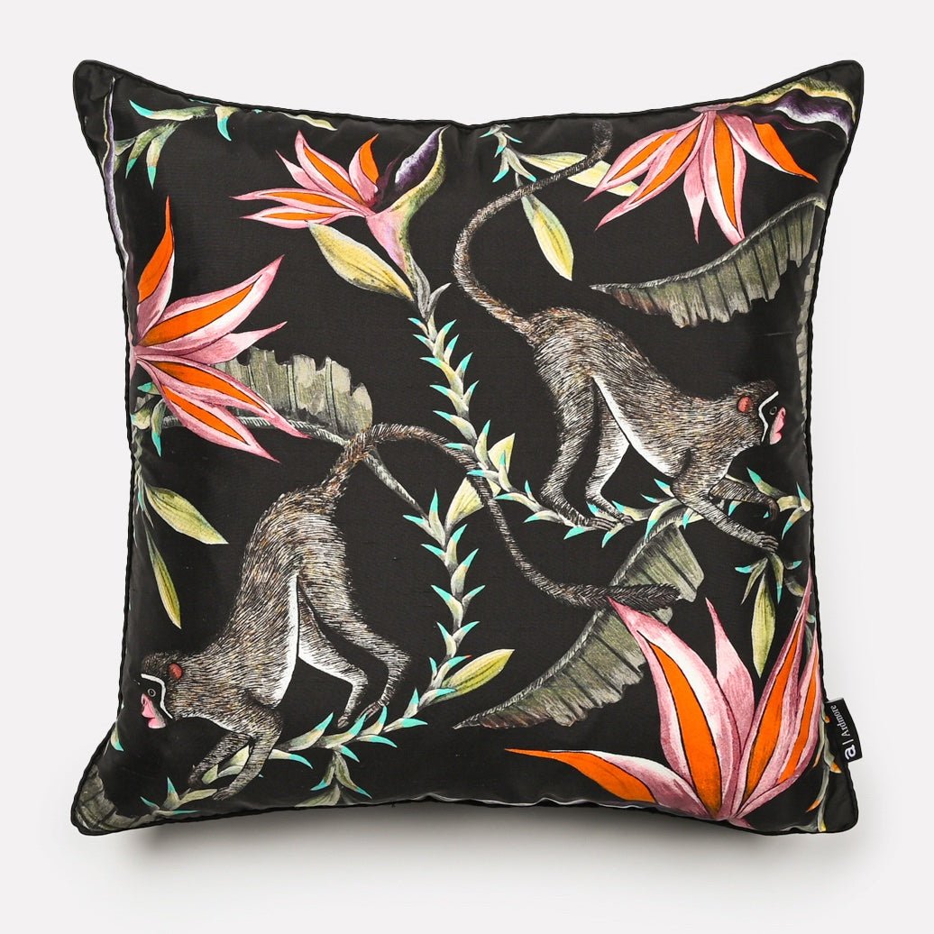 Front view of the Monkey Paradise Night Silk Cushion Cover featuring playful monkeys amidst vibrant tropical foliage on a black background.