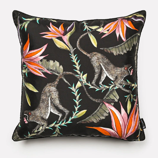Front view of the Monkey Paradise Night Silk Cushion Cover featuring playful monkeys amidst vibrant tropical foliage on a black background.
