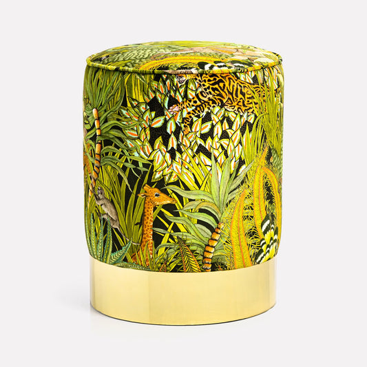 Luxurious velvet pouffe adorned with Ardmore's Sabie Forest Delta fabric, featuring vibrant jungle-inspired motifs and perched elegantly on a polished brass base.