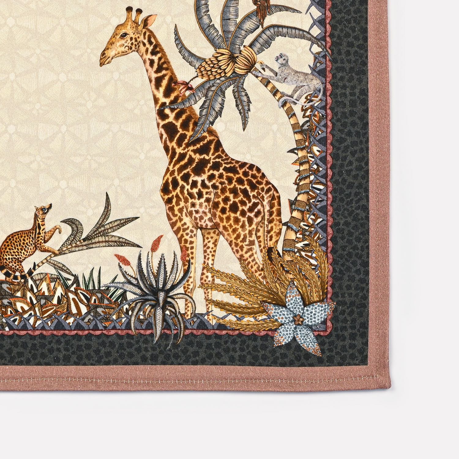 A close-up of the Ardmore Sabie Forest Napkin in Stone, highlighting a gracefully illustrated giraffe alongside rich botanical patterns near the napkin’s edge.