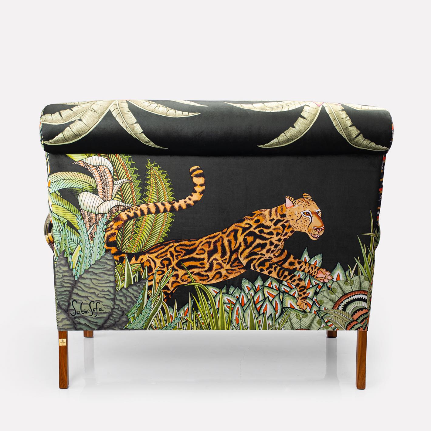 Close-up of the sofa’s backrest, highlighting the depth and texture of the velvet fabric adorned with vibrant foliage.