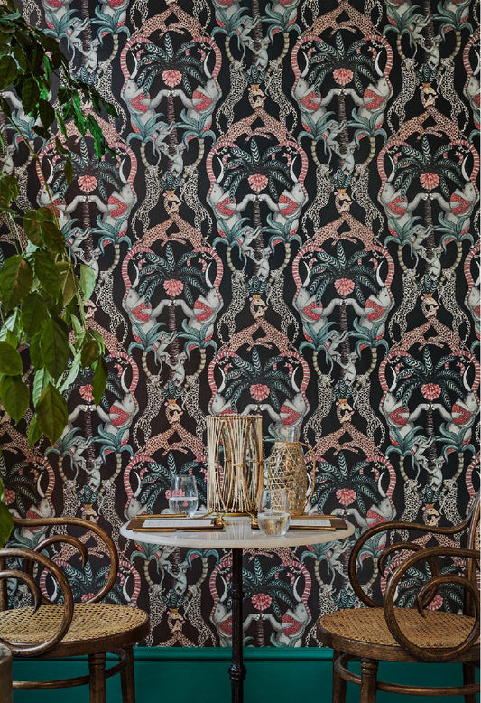 A dining space featuring the wallpaper’s intricate depiction of leopards, giraffes, and elephants interwoven in a totemic design.
