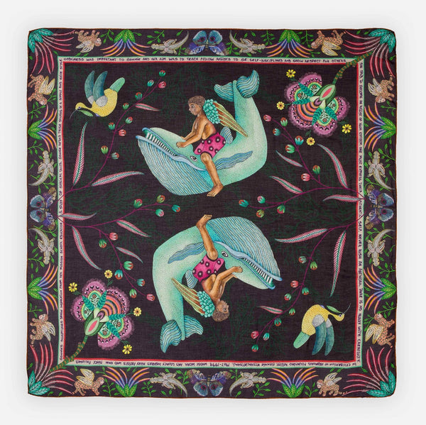 A limited-edition wool and modal wrap featuring a celestial-inspired design with soft blue birds, golden chains, and vibrant floral elements against a deep midnight background.