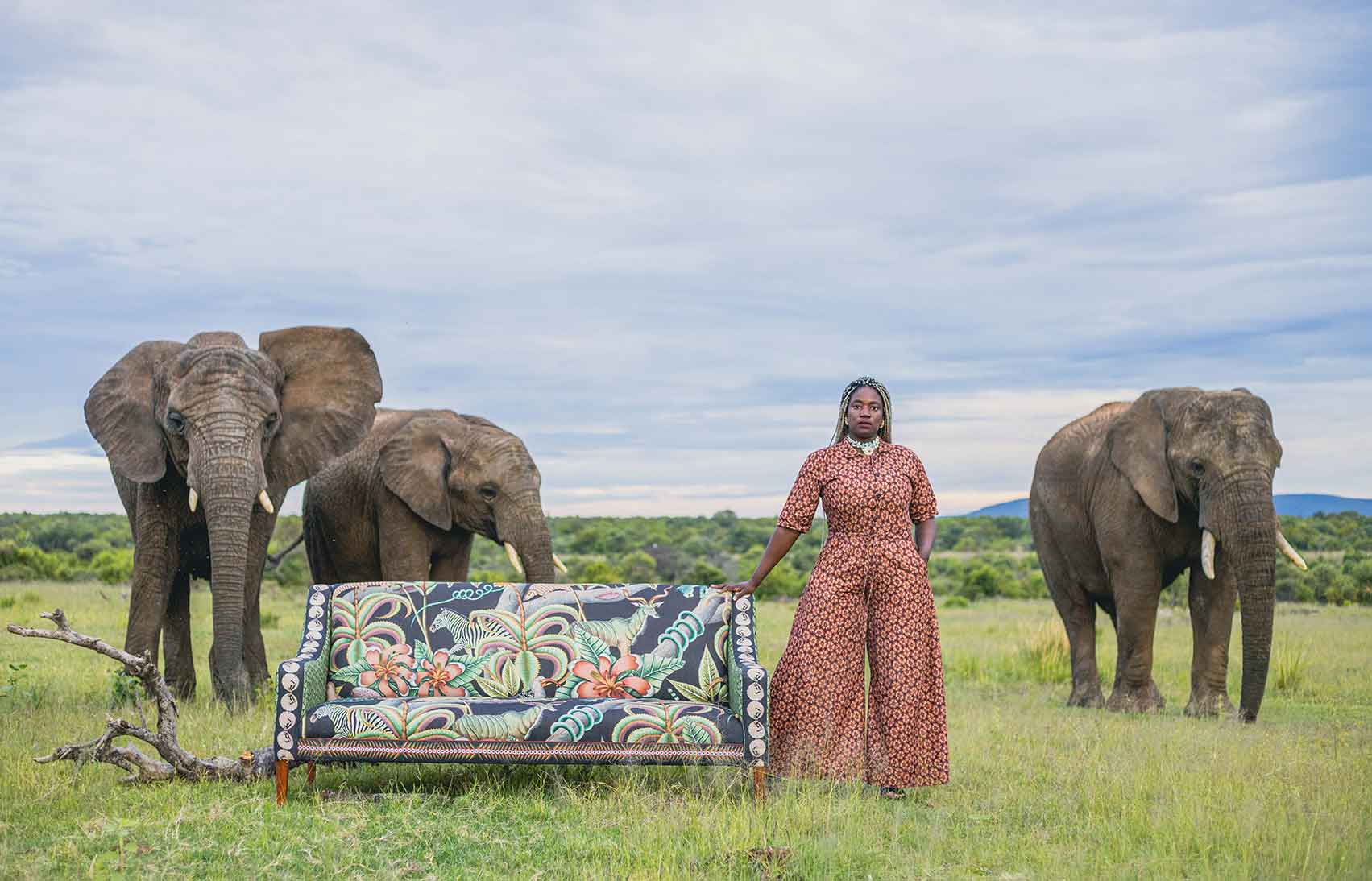 Lifestyle image featuring the Ardmore Thanda Sofa Limited Edition in an open landscape, with elephants in the background, merging high-end craftsmanship with wildlife aesthetics.